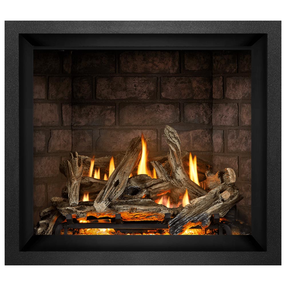 Direct vent gas fireplace with dark frame, burning logs and orange flames on brown brick wall