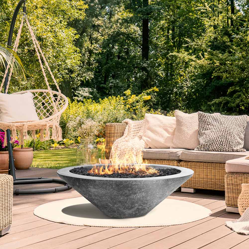 Concrete gas fire pit on patio with flame, surrounded by outdoor seating.