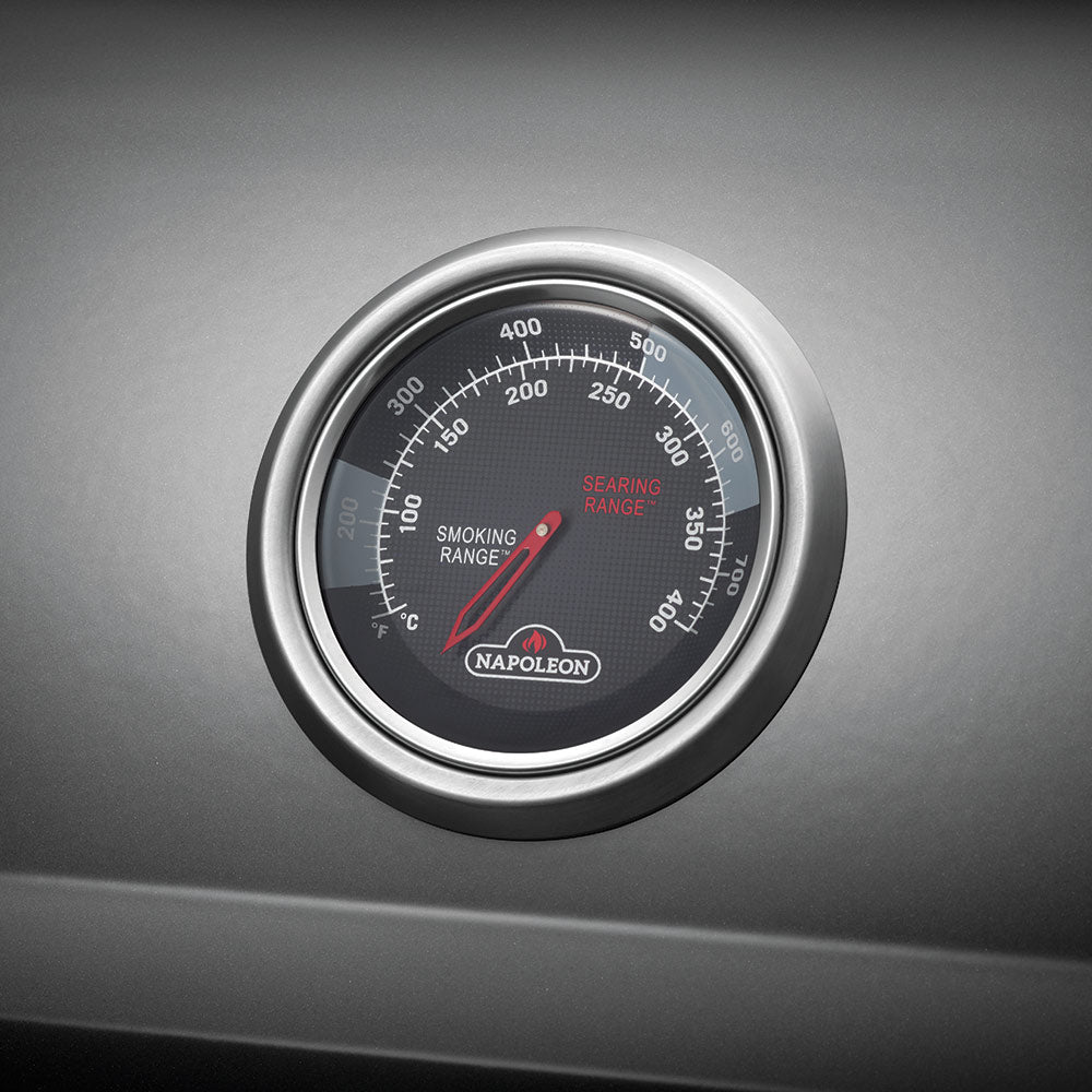 Round temperature gauge on the propane gas grill lid with smoking range markings