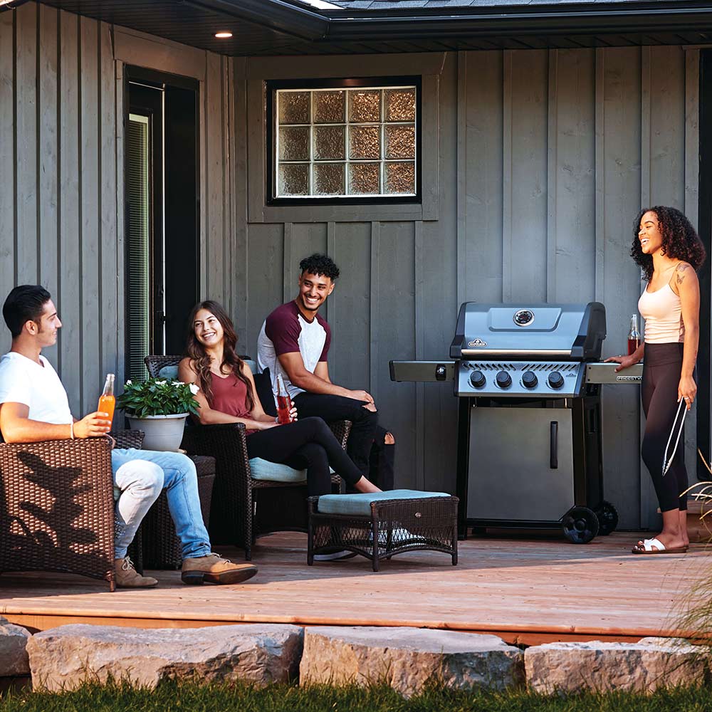 Freestyle 425 gas grill on cart on patio with lid and side shelf, black