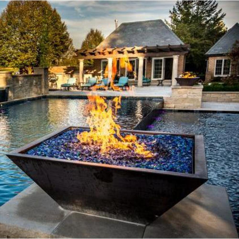 Square gas fire bowl with tall flames burning in a blue base pan, dark copper