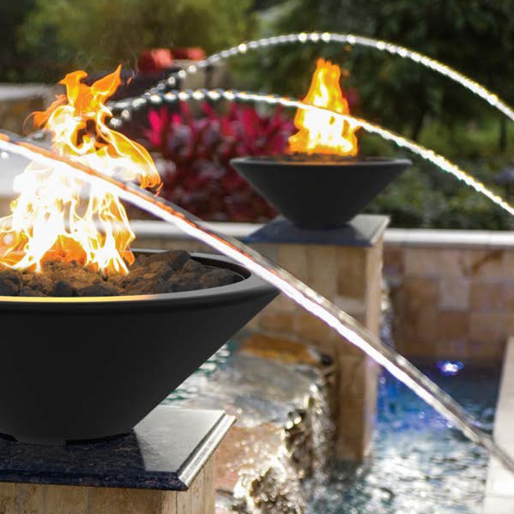 Dark gray concrete gas fire bowl with flames and burner opening on an outdoor patio