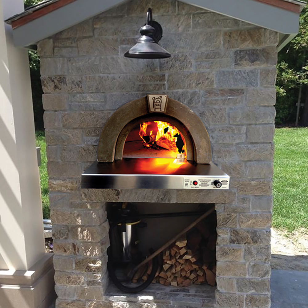 Built-in pizza oven in a stone enclosure with open arched opening and fire