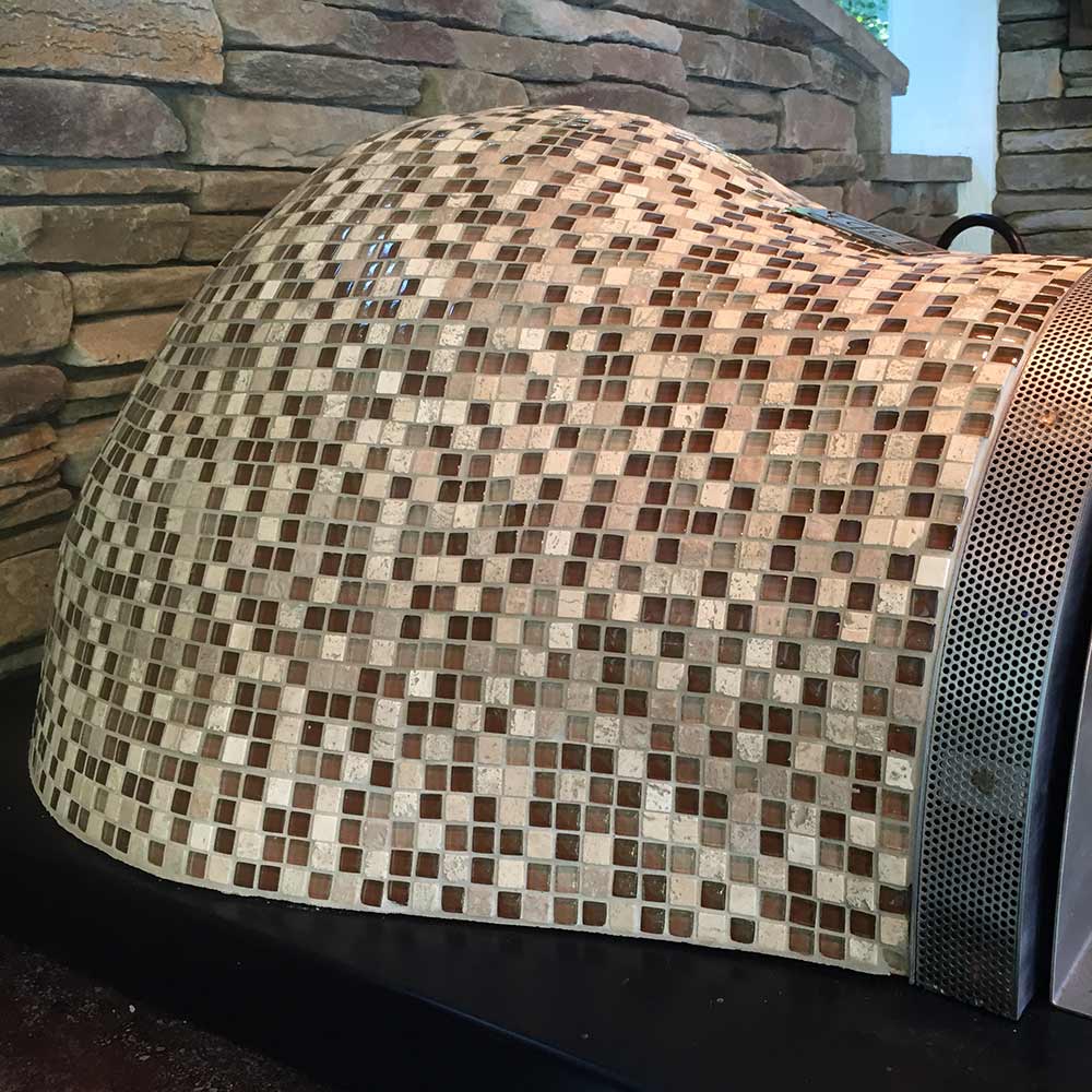 Glass tile pizza oven dome with multicolor mosaic pattern and black side vent