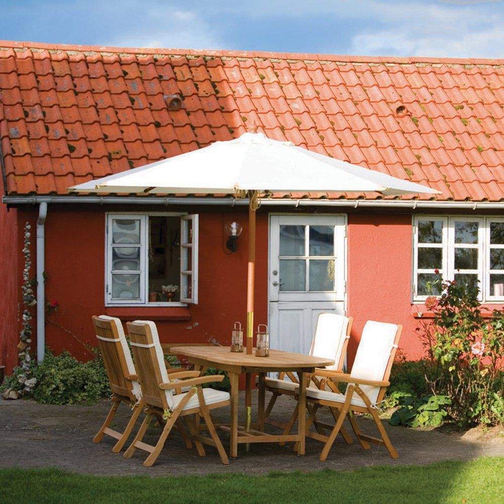 Teak oval dining table with extension leaf, shown with chairs on patio