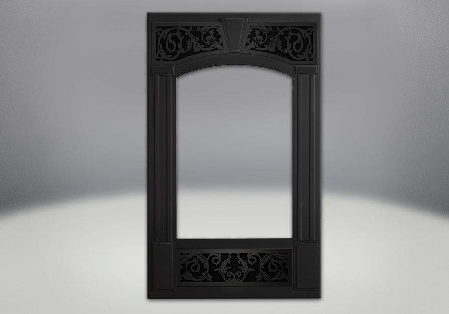 Decorative fireplace facing kit with ornate black frame and arched inner glass panel