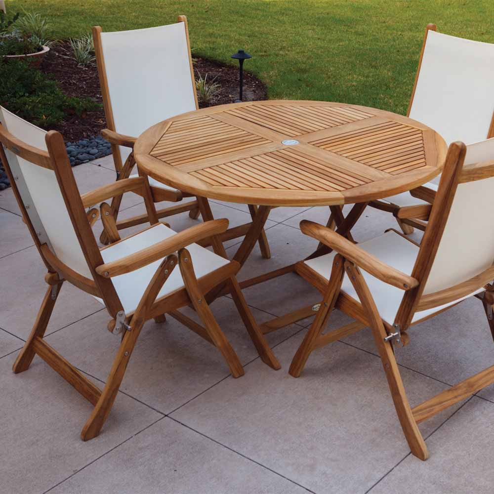 Teak sling chair with white fabric seat and backrest on a patio near a round table