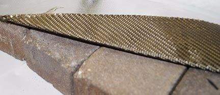 Woven basalt fabric insulation strip with stitched edge for fire pit deck, on pavers