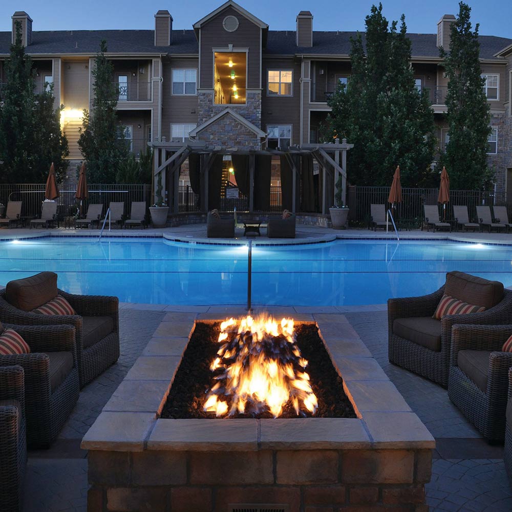 Outdoor rectangle fire pit with gas burner flames and burning logs