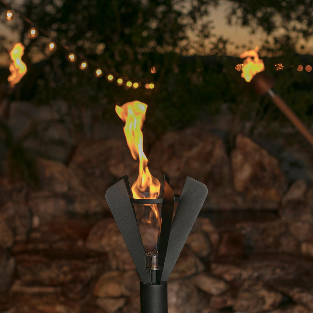 Black fin-style gas torch burning flame from the central burner