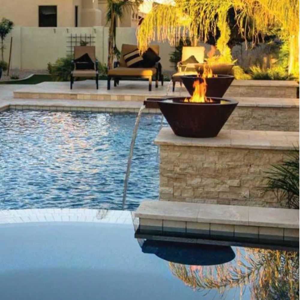 Round copper fire and water bowl spilling water into a pool with flames.