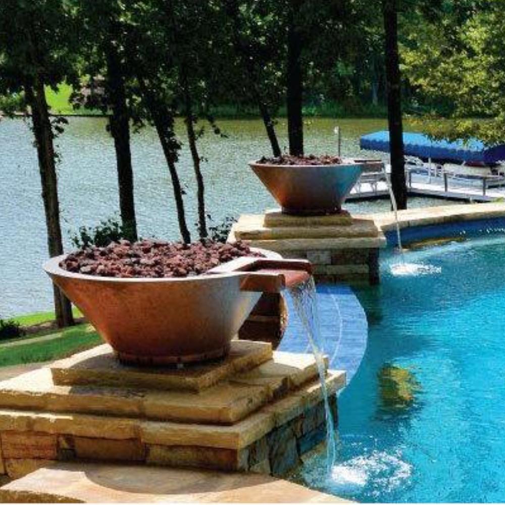 Round copper fire and water bowl at poolside with blue fire glass and flames