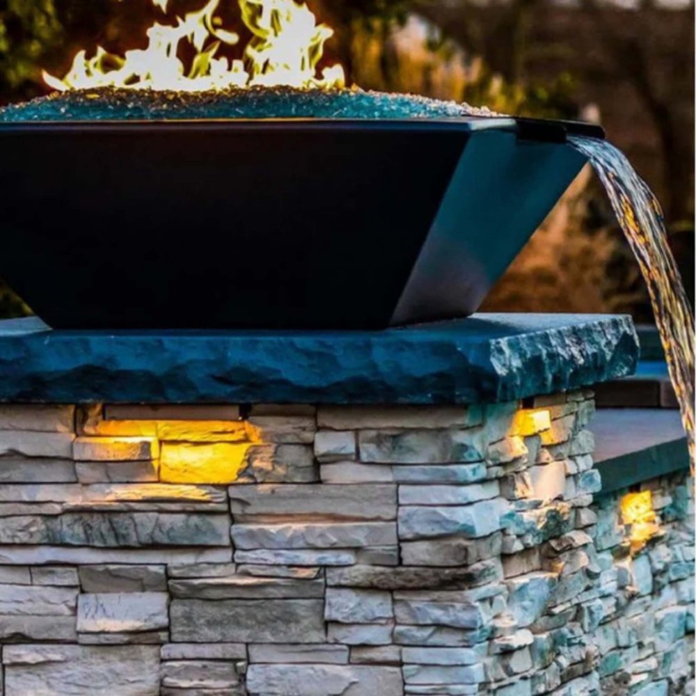 Dark concrete fire and water bowl pouring water with open flames at the top