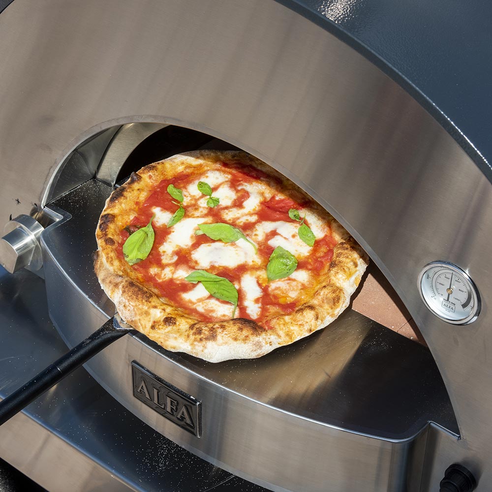 Alfa gas pizza oven with pizza inside showing melted cheese and basil leaves