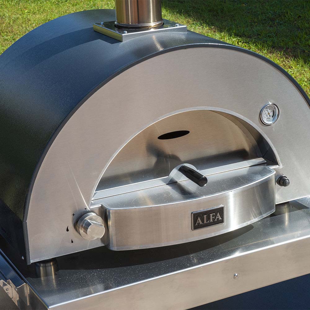 Pizza oven open front with stainless peel resting in the cooking chamber.