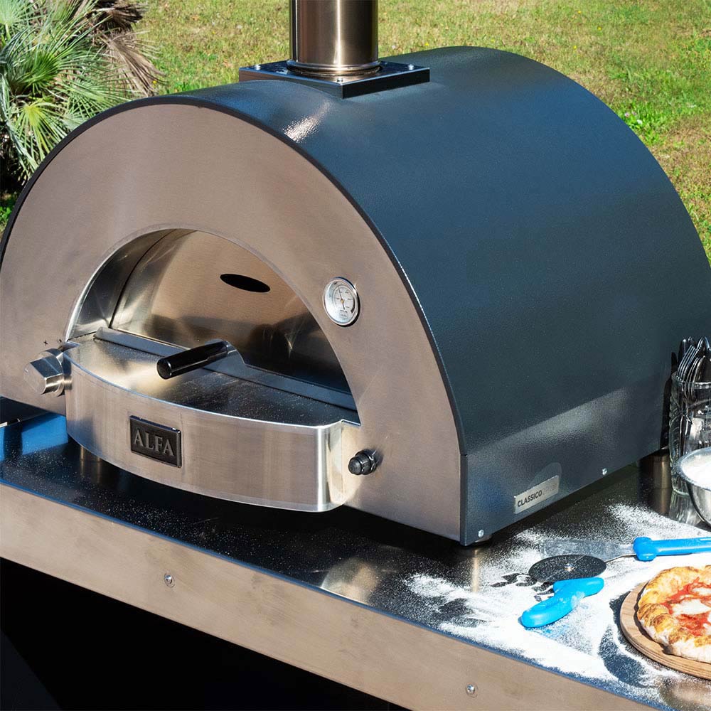 Pizza oven angled view with open door, stainless hearth, and front thermometer.