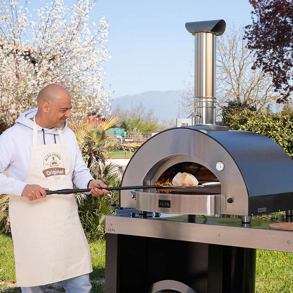 Stainless gas pizza oven with open chamber and standing chimney outdoors