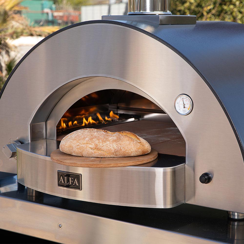 Gas pizza oven interior with baking stone and whole pizza in active flame