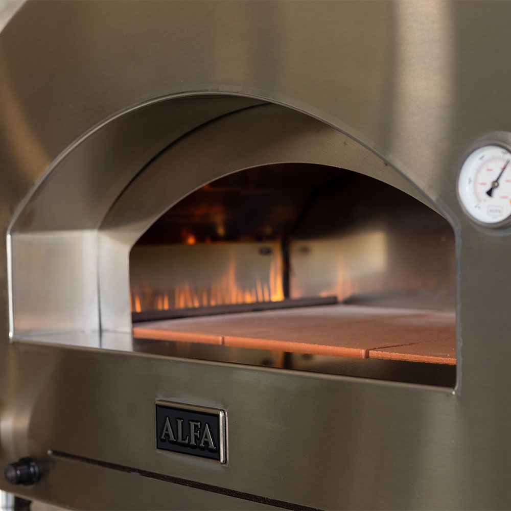 Countertop gas pizza oven interior with visible flames and stone baking deck