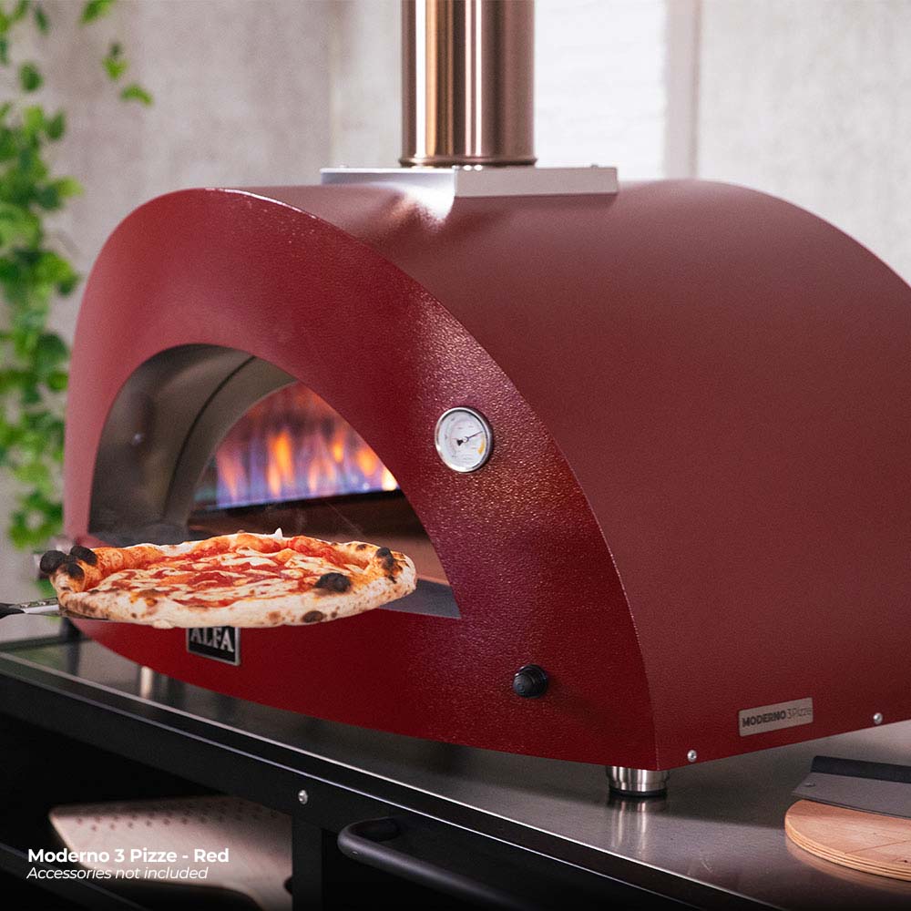 Ruby red gas pizza oven with arched opening, two pizzas baking, and stainless chimney