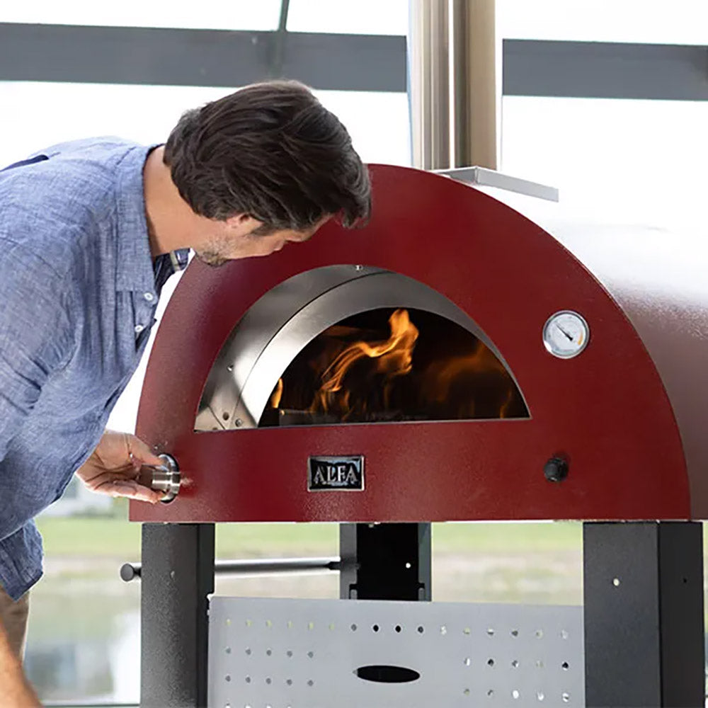 Freestanding gas pizza oven with open front, visible flames inside red fire dome