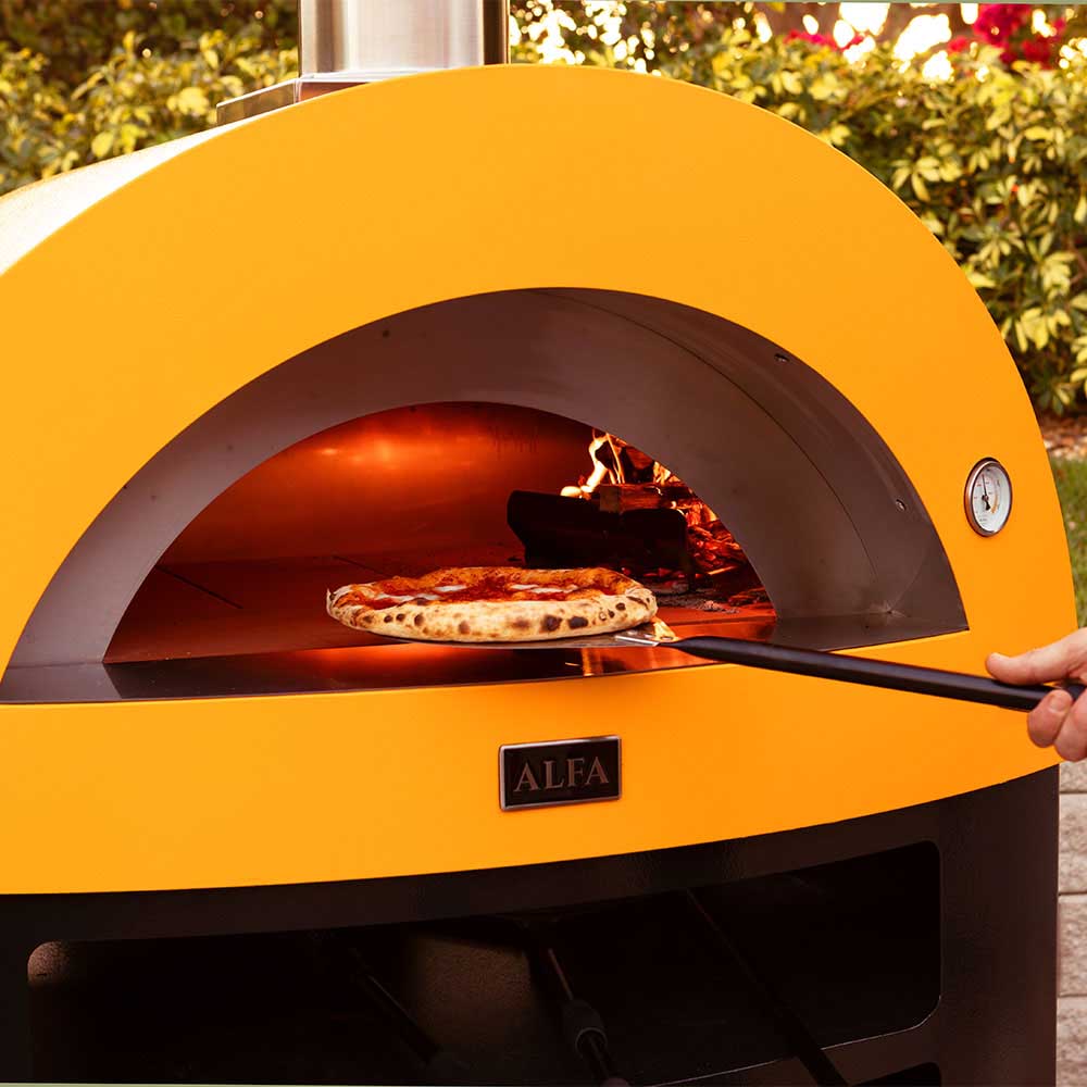 Gas pizza oven interior with yellow dome and a pizza baking over open flames