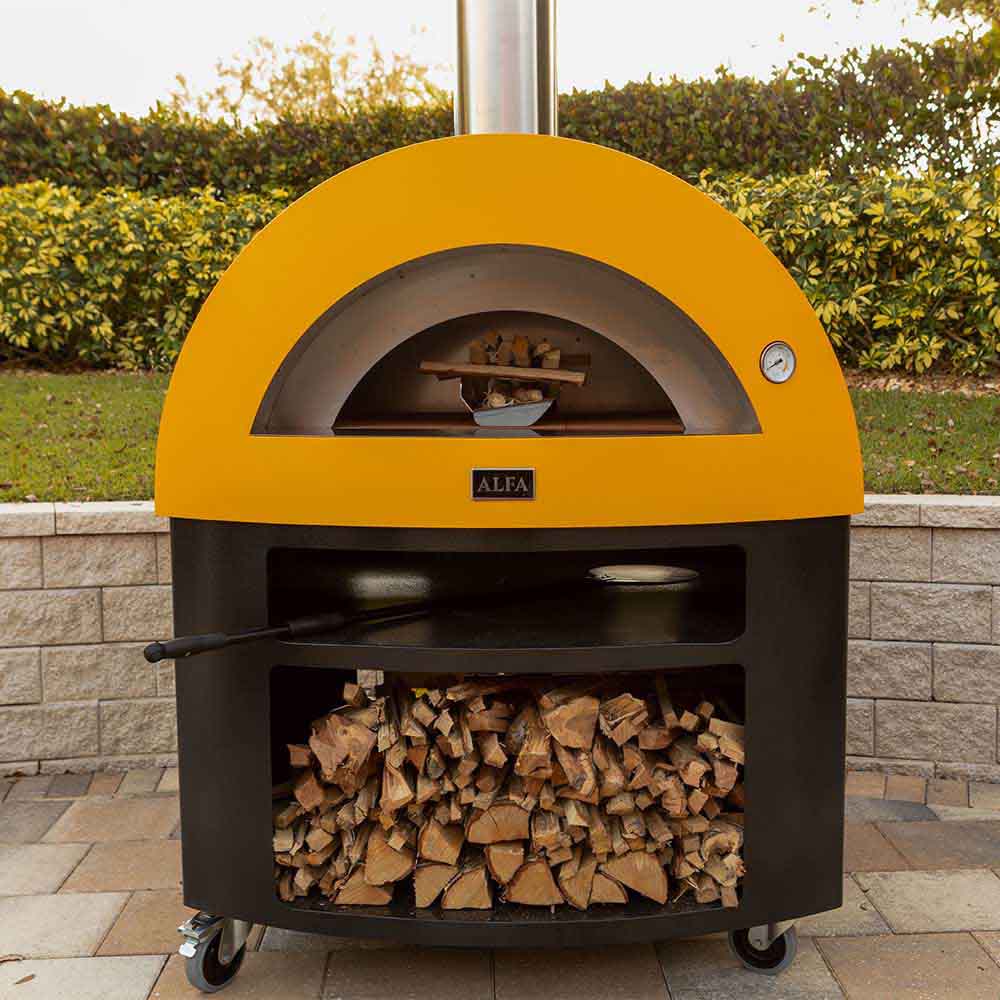Outdoor gas pizza oven with yellow dome, open front showing wood logs inside storage.