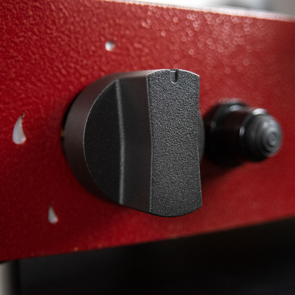 Round control knob on red portable gas pizza oven side panel