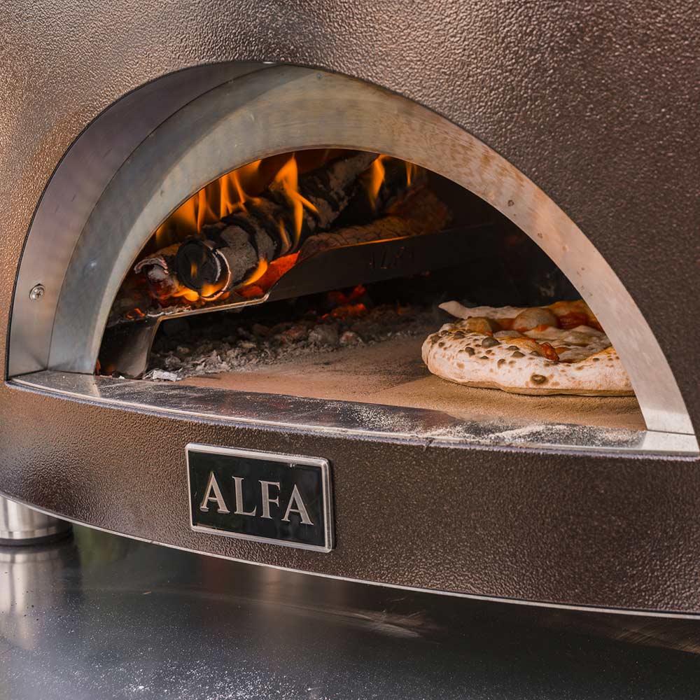 Wood-fired pizza oven interior with open arched mouth, burning logs, and pizza stone surface
