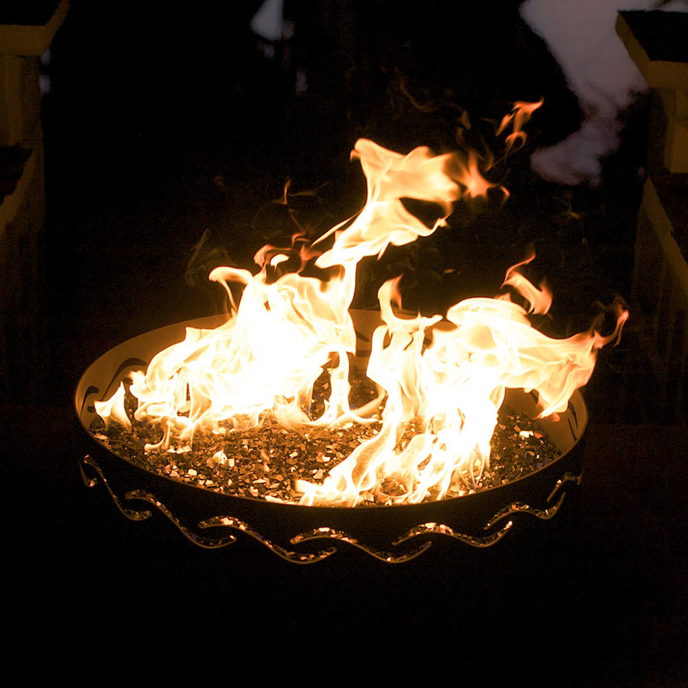 Gas fire pit with large flames in round bowl and black metal wave pattern