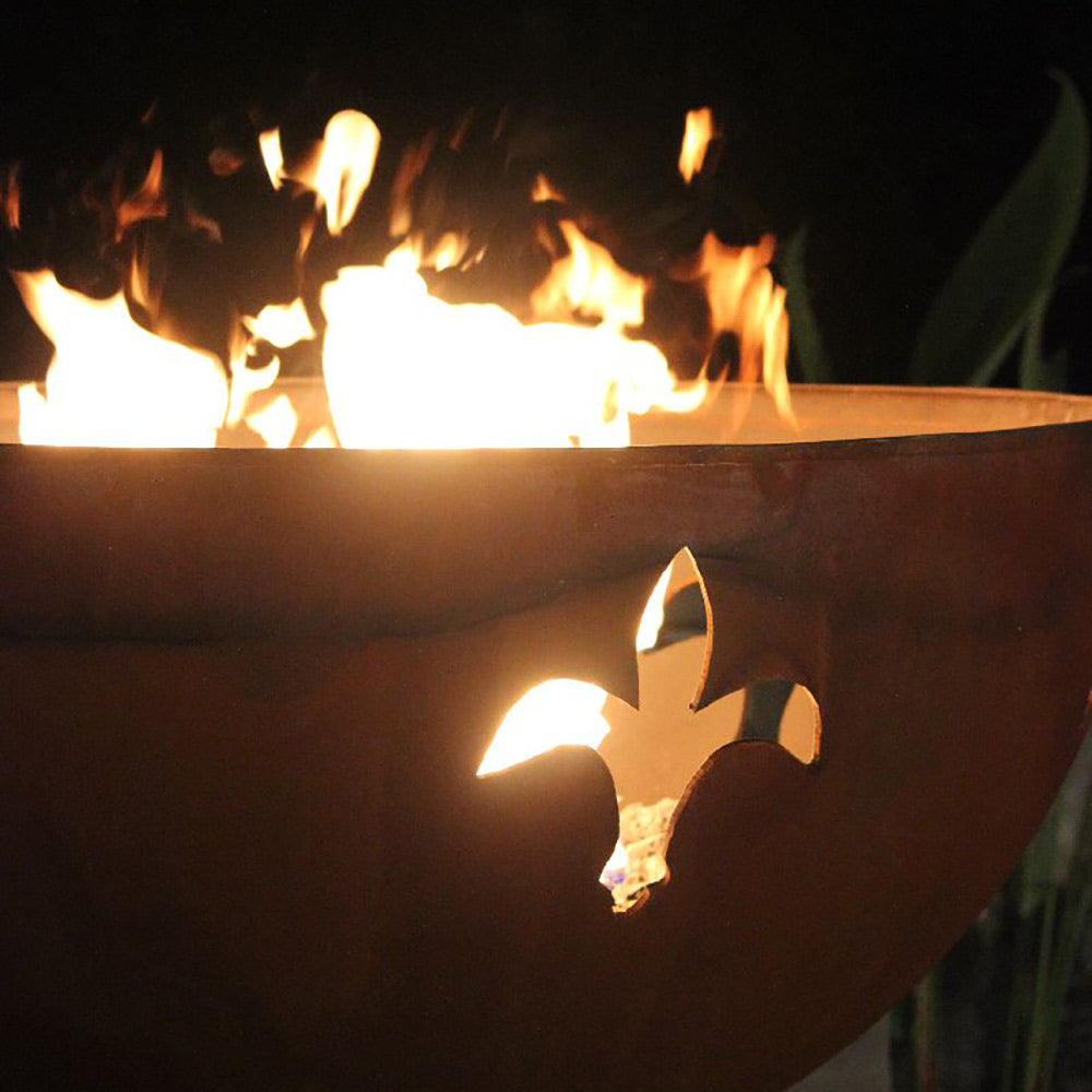 Gas fire pit with flames rising from the bowl opening and fleur de lis cutout