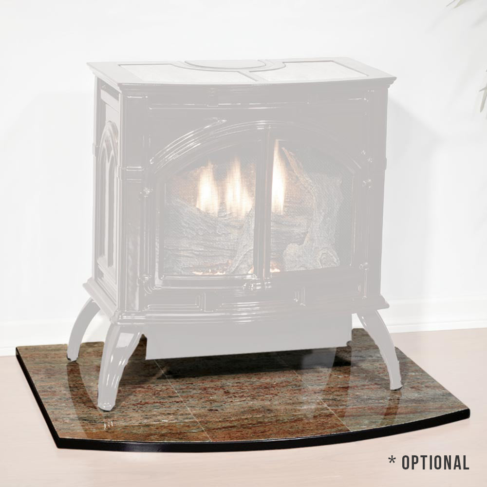 White cast iron stove with glass firebox and decorative feet on a stone base