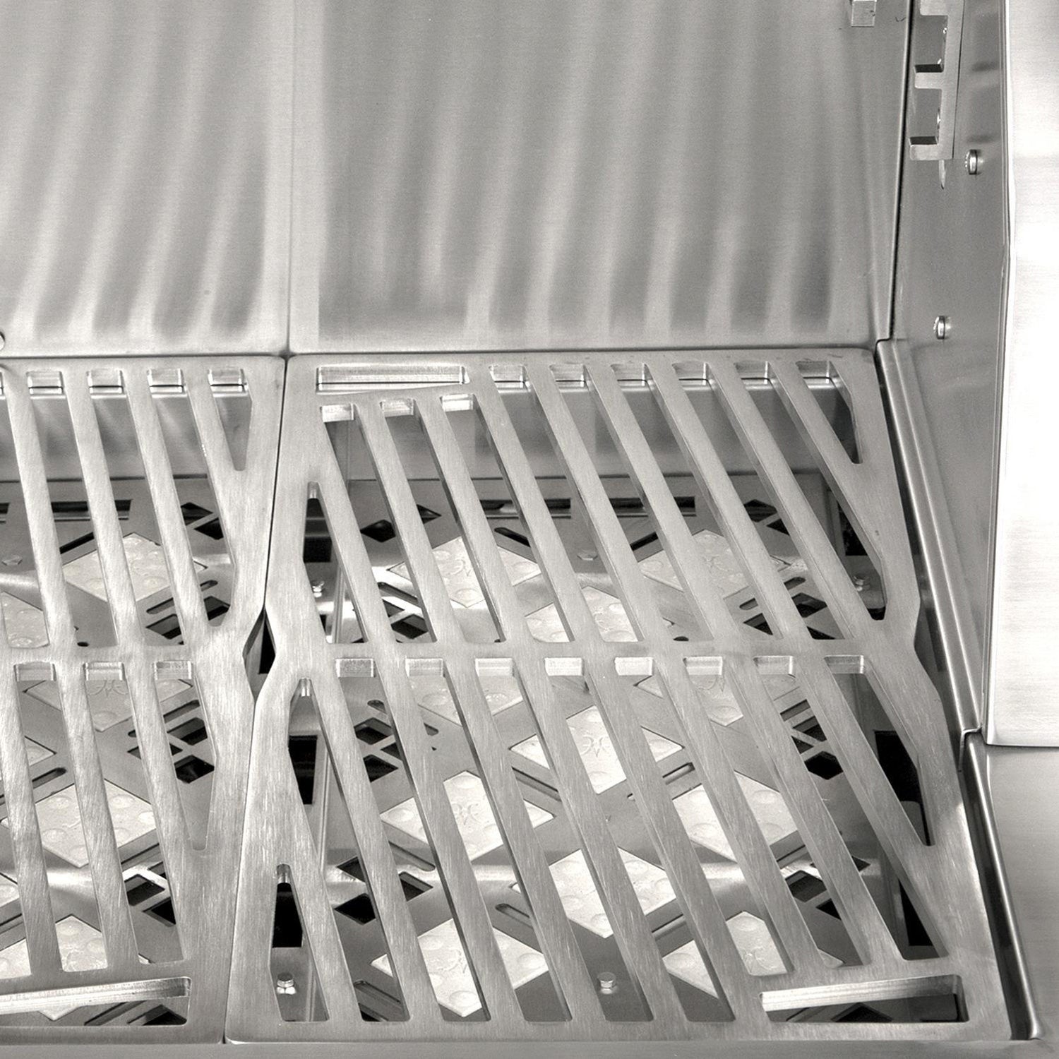 Stainless grill firebox interior with angled metal grates and burner housing