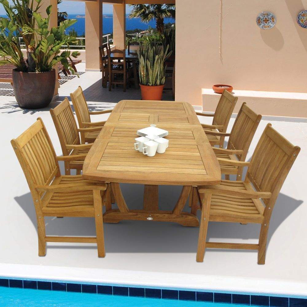 Teak rectangular dining table with slatted surface and pedestal base, surrounded by chairs