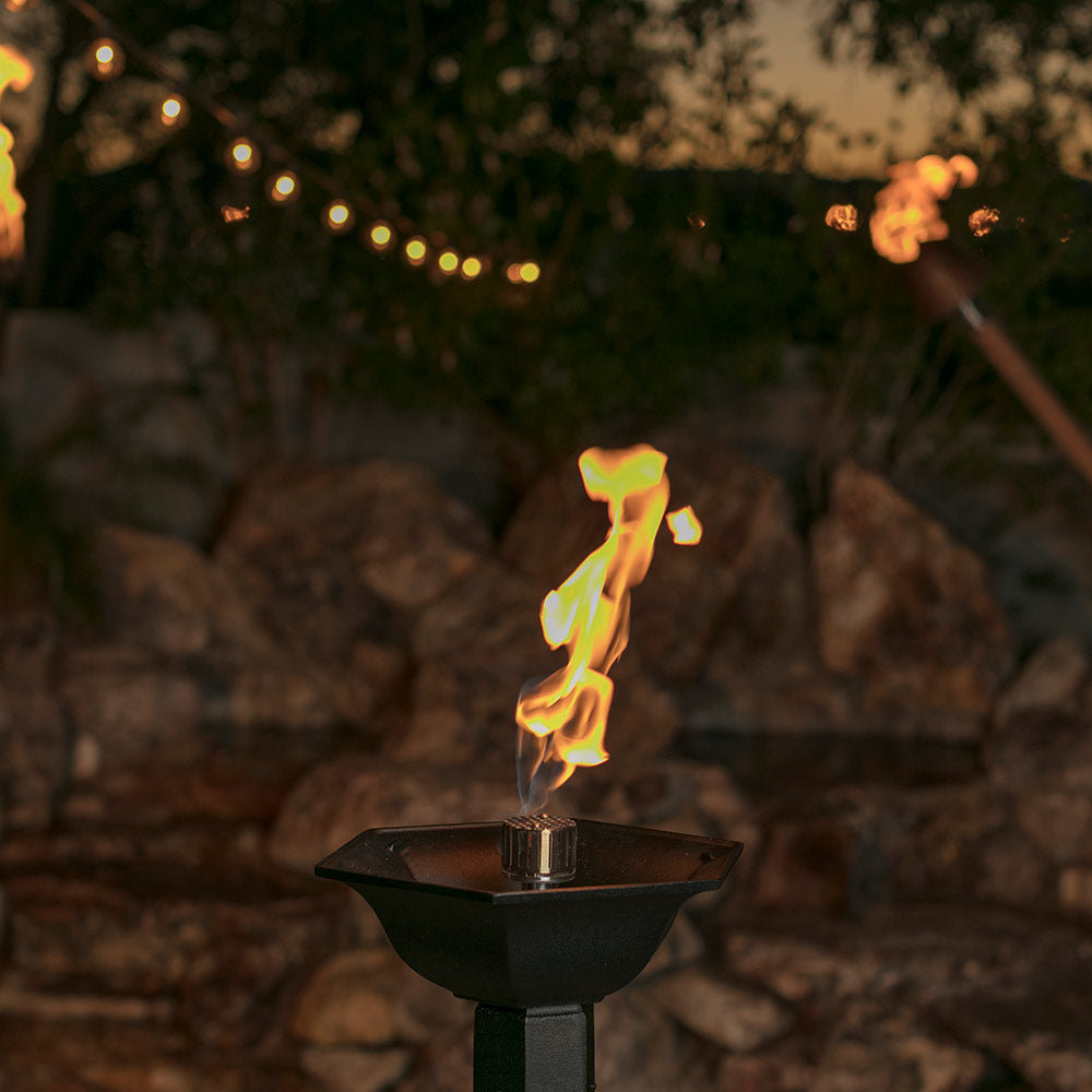 Gas torch head on pedestal with tall blue-yellow flame