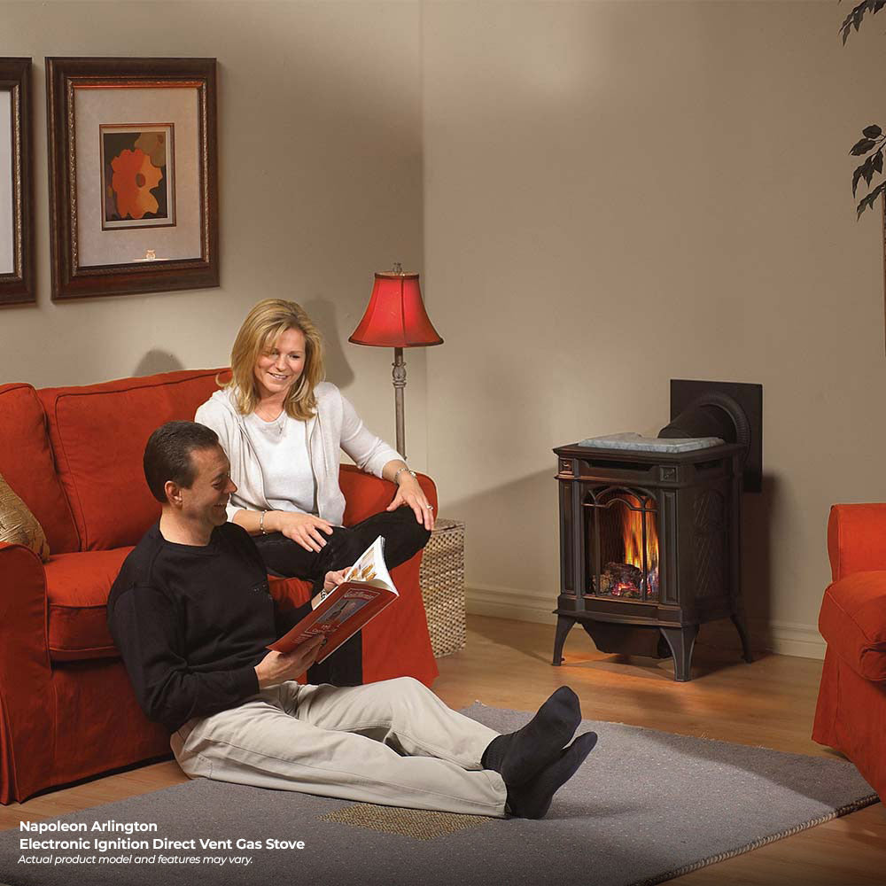 Black cast iron direct vent stove with fire burning in living room setting