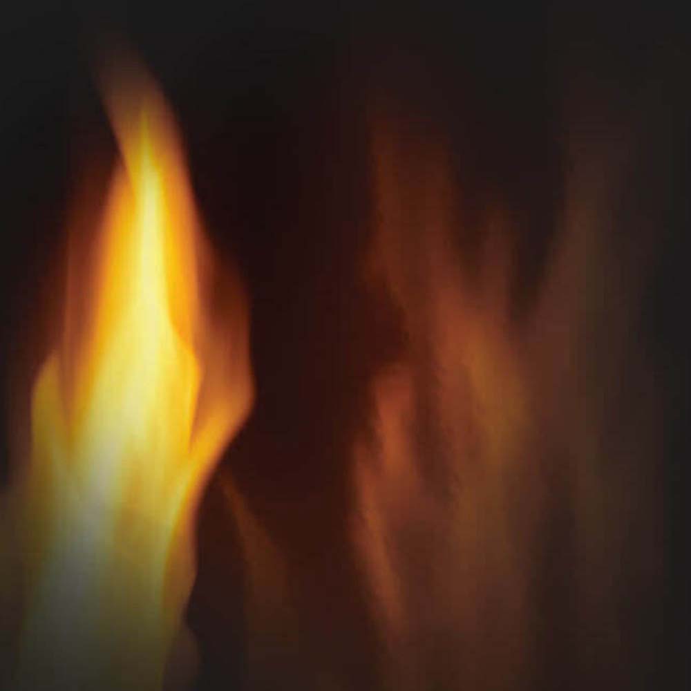 Flame detail behind stove screen with glowing logs and orange-yellow fire