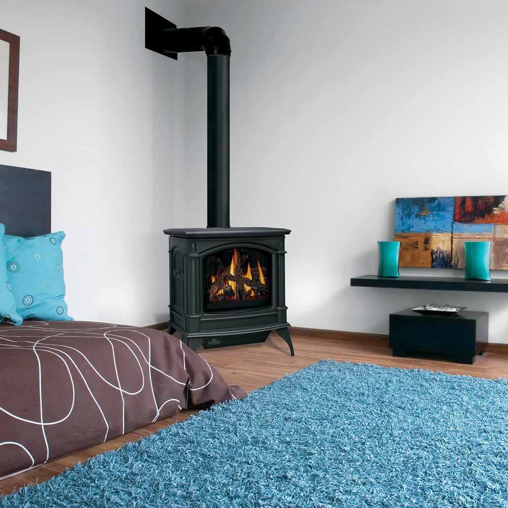 Black direct vent gas stove with chimney flue and glass firebox, flames burning
