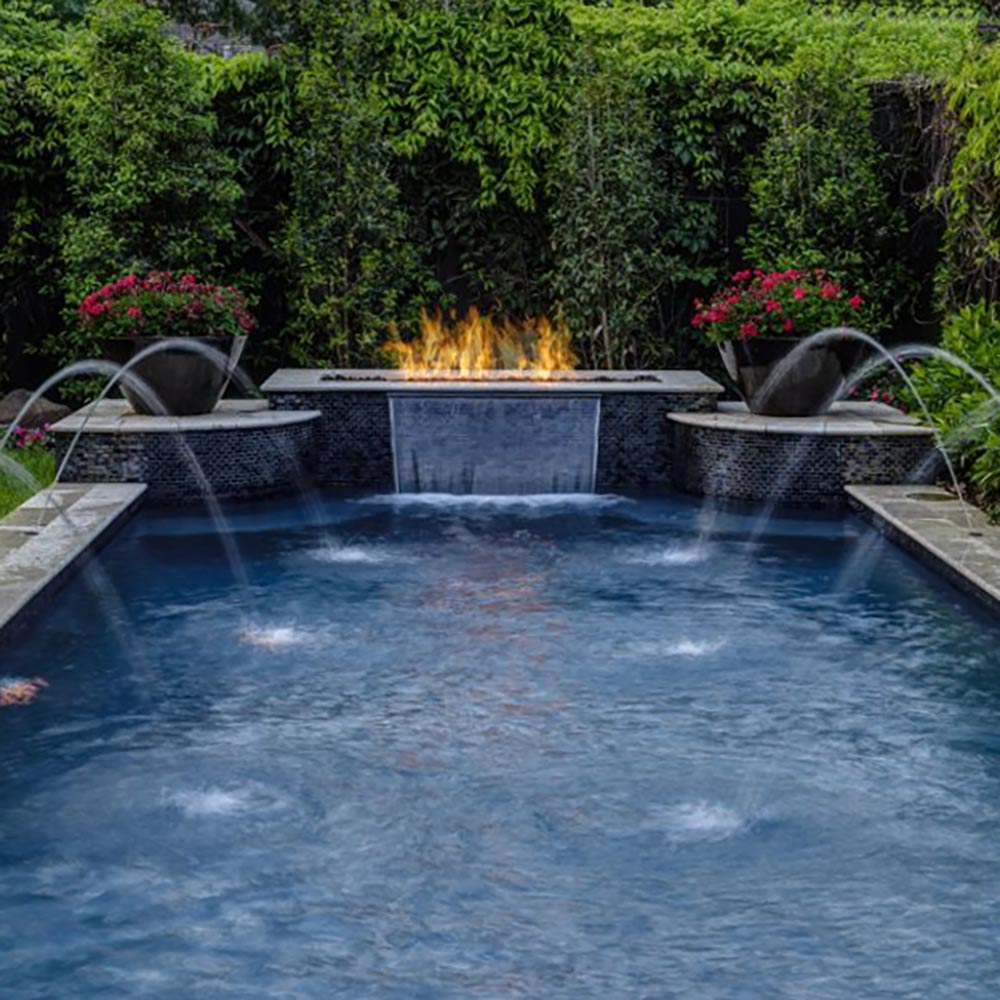 Poolside outdoor gas fire pit burner with visible flames