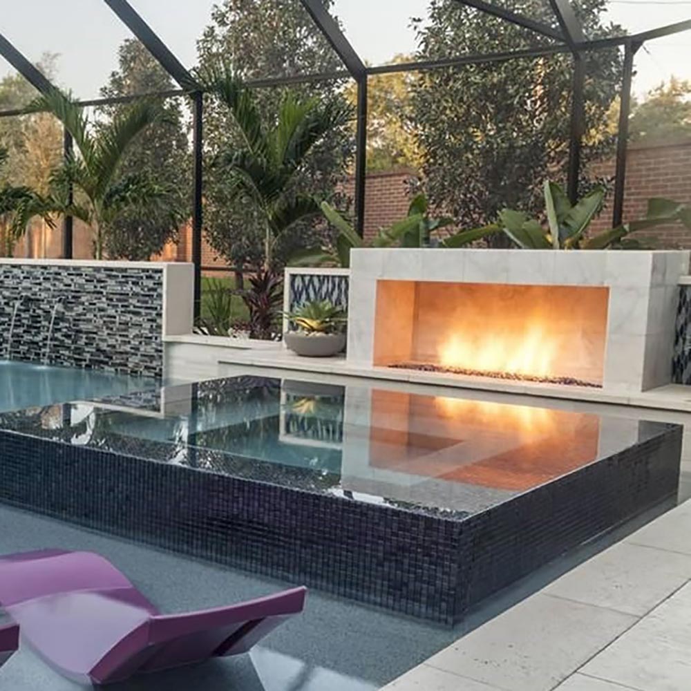 Outdoor linear gas fire pit flame burning inside a raised metal firebox