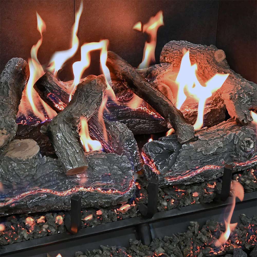 Charred wood gas log set close-up with flames over glowing embers and log grate
