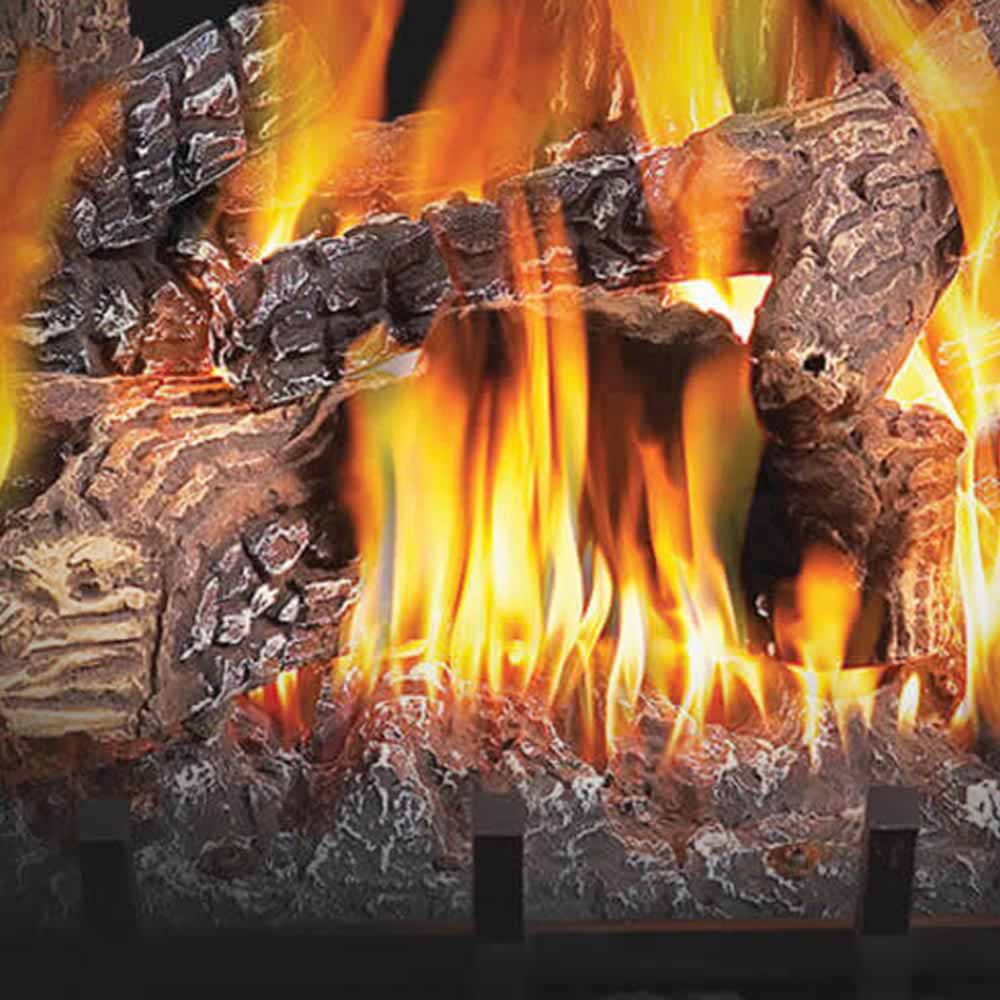 Close-up of burning flames on faux charred logs in a vented gas log set.