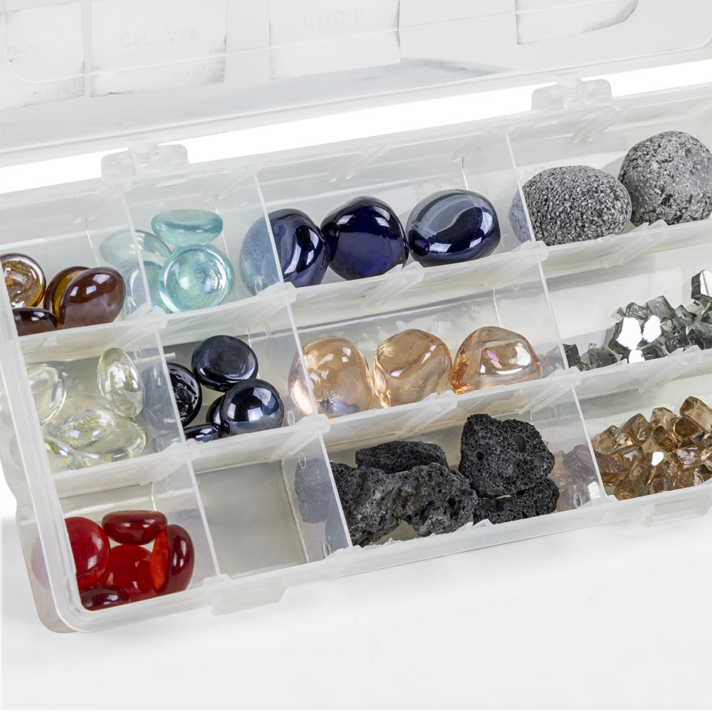 Fire glass sample box section with dark lava rocks and blue, amber, and clear glass pieces