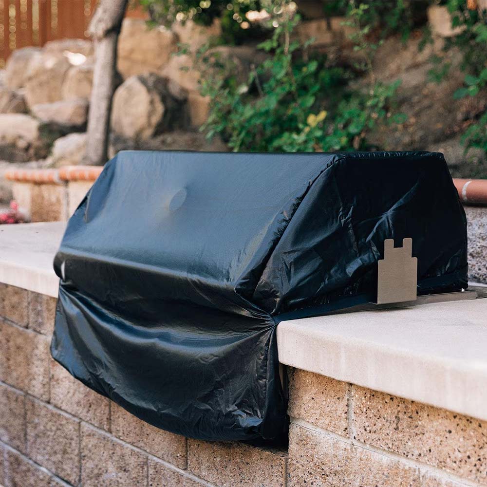 Built-in grill cover, dark gray, draped over grill on a stone counter