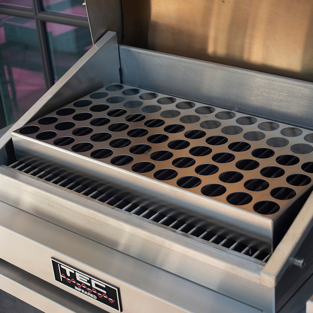 Pizza oven rack insert with round holes in metal frame inside oven