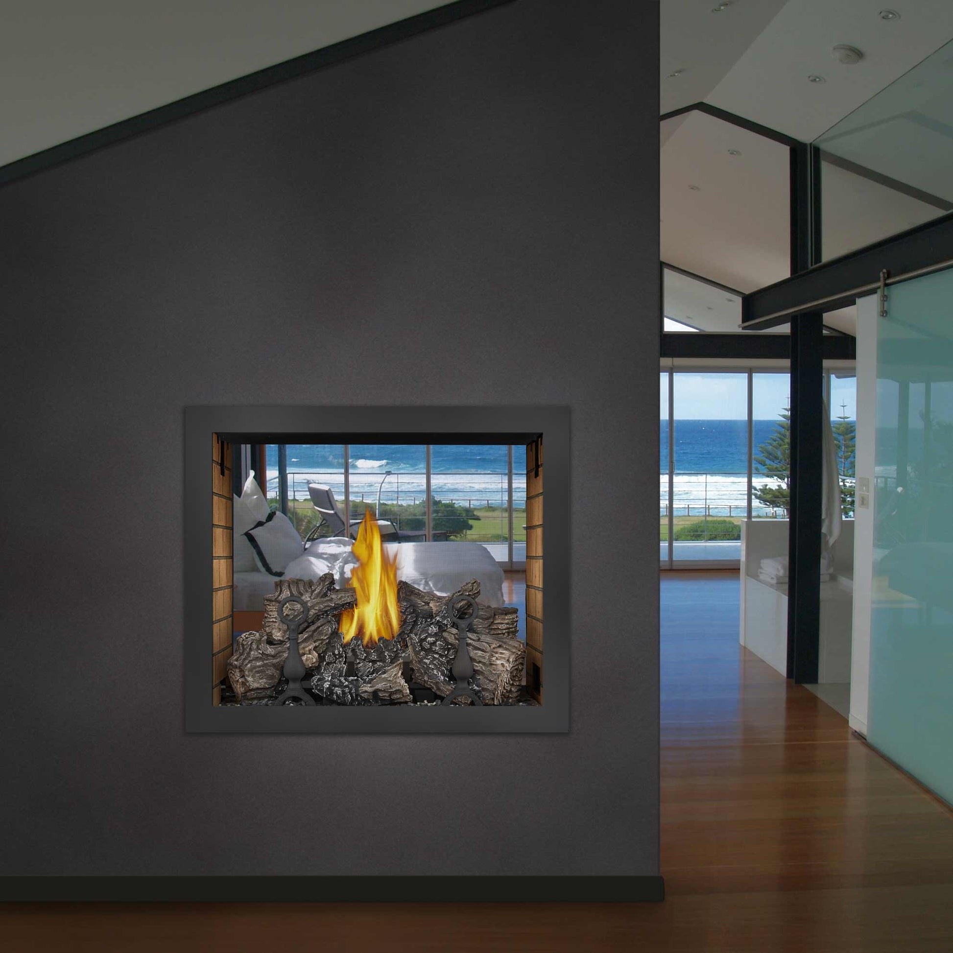 Double-sided gas fireplace insert with dark river rock and flame, set into a wall