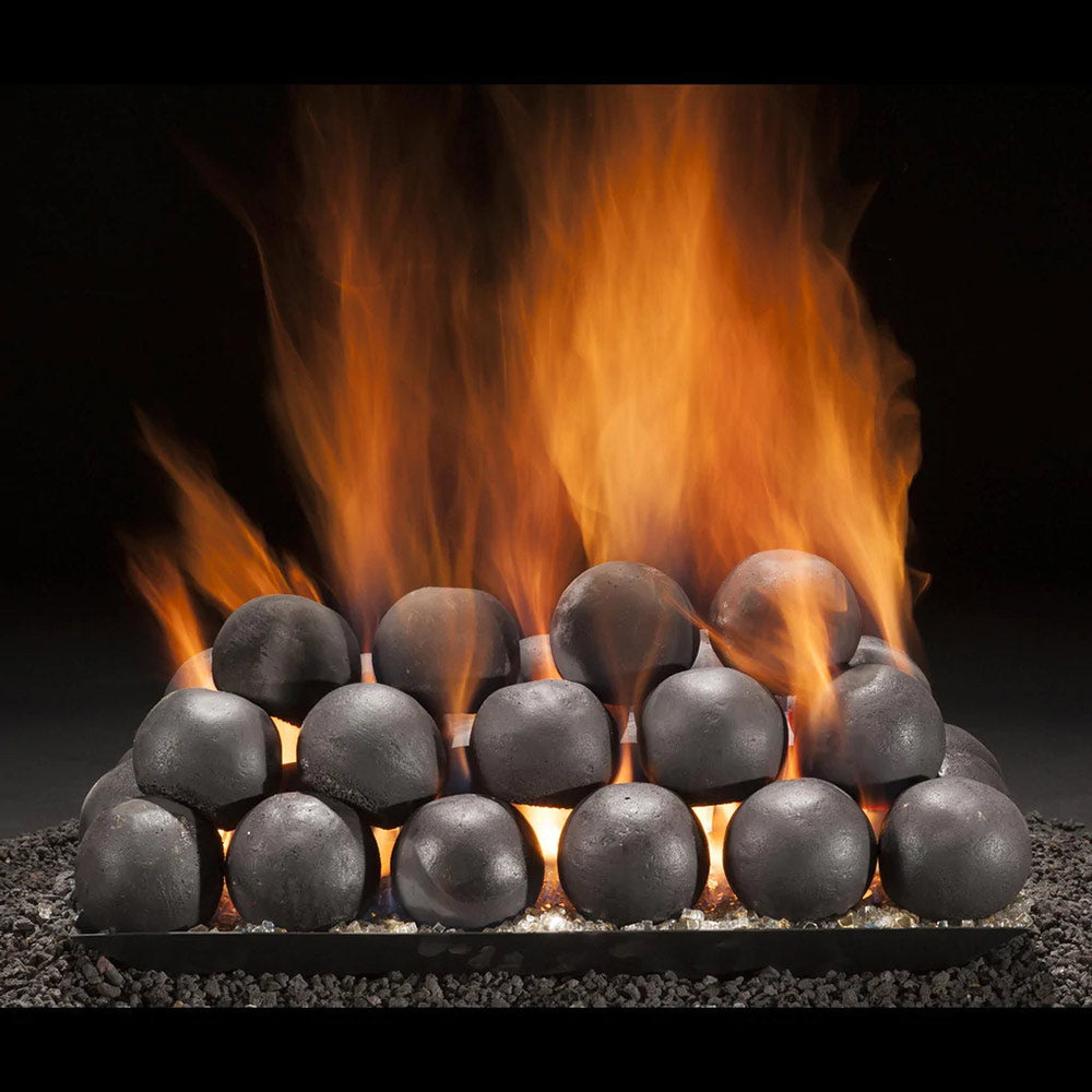 Dark 4-inch metal cannon balls on fire pit stones