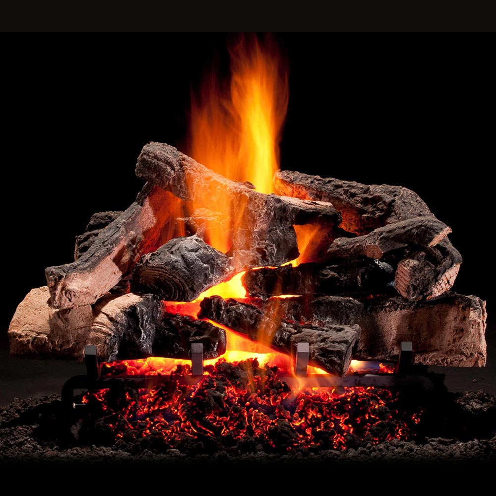 Vented gas logs set with stacked dark logs and bright orange flames