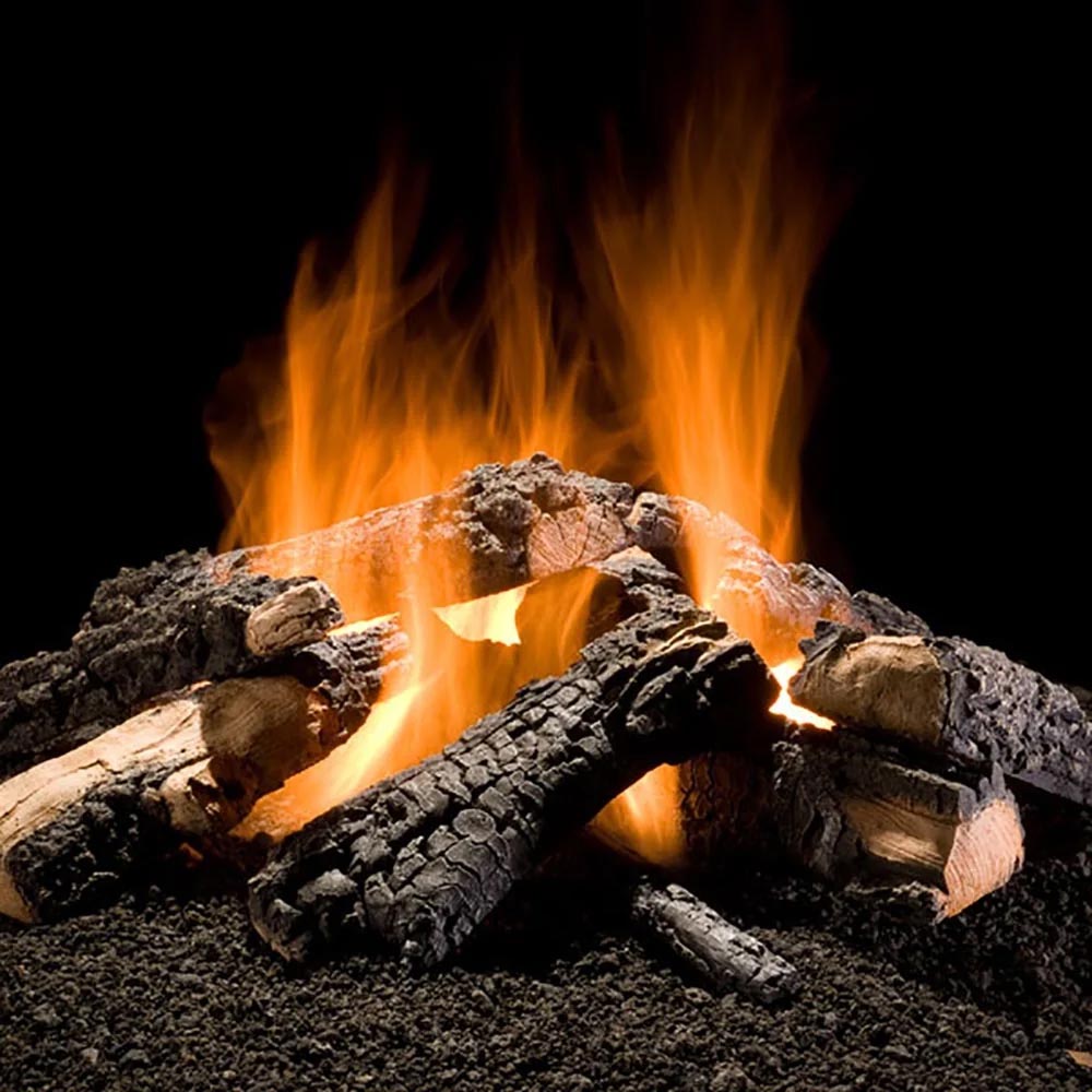 Outdoor gas fire logs with glowing orange flames and charred log pieces