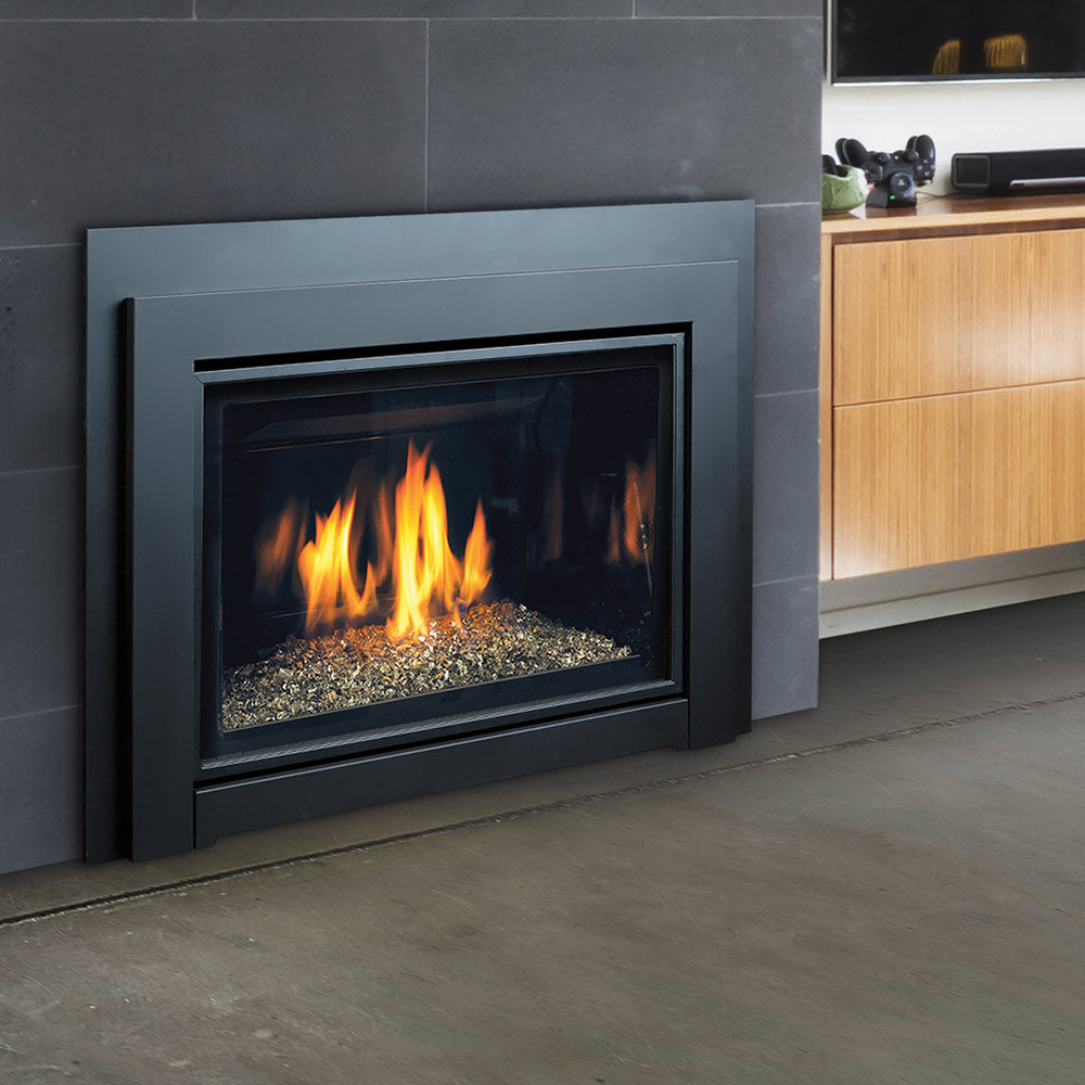 Gas fireplace insert with black frame and glass window, burning flames over gray media